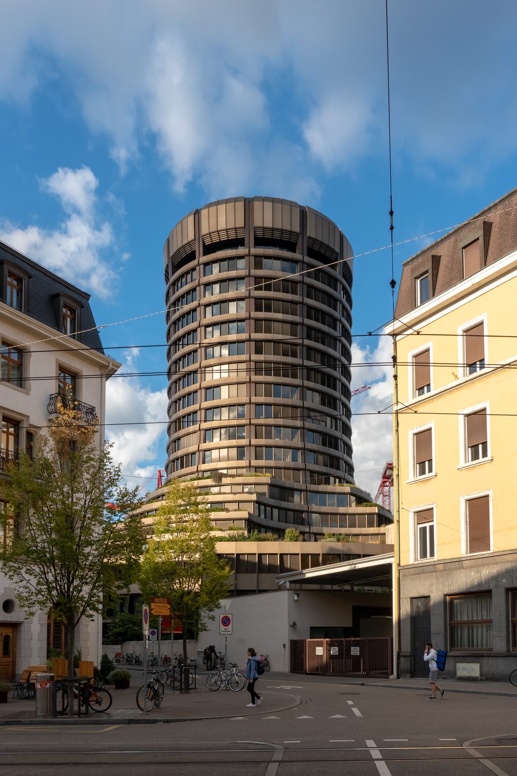 The circular BIS Tower in Basel, Switzerland, rising above the city's rooftops in late-afternoon light
