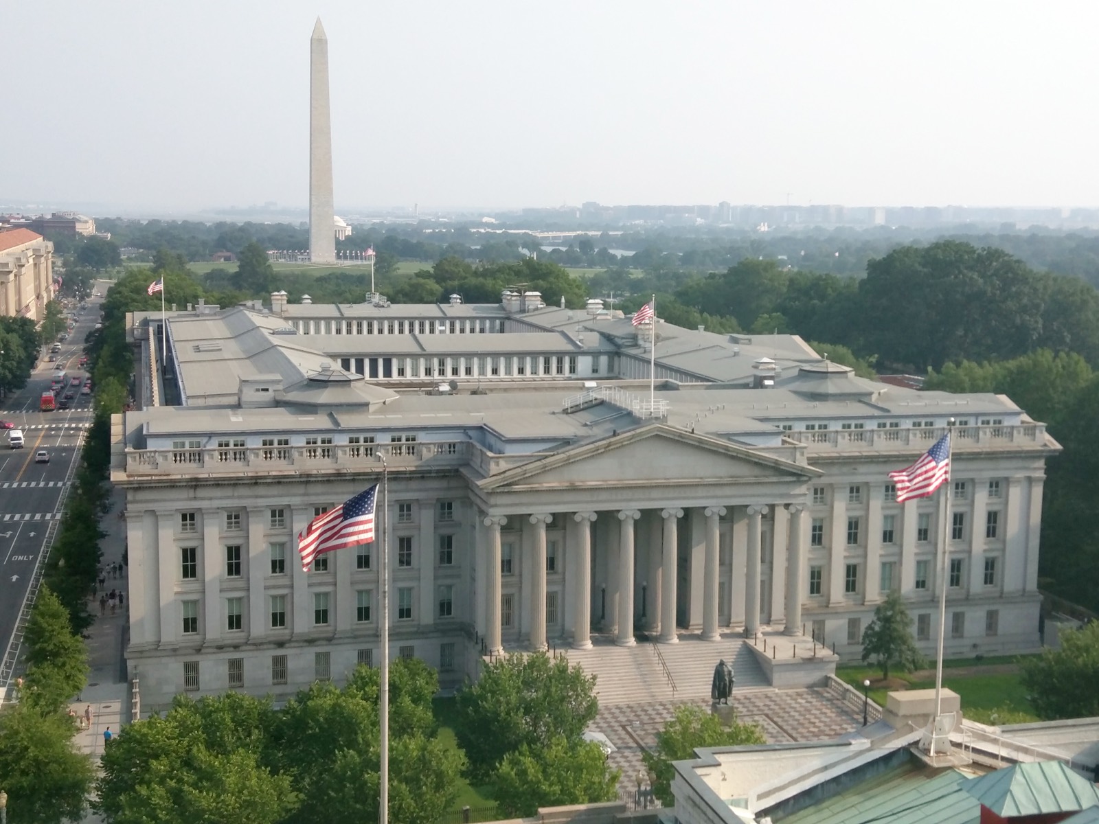 The United States Treasury Building in Washington, D.C., photographed from above, with the Washington Monument visible in the distance